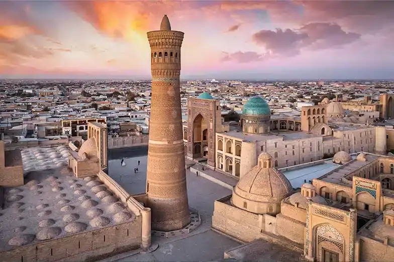 Kalyan minaret above the rooftops of Bukhara at sunset